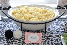 a bowl filled with macaroni and cheese on top of a black and white table cloth