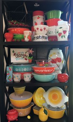 a shelf filled with lots of colorful dishes and bowls on top of eachother