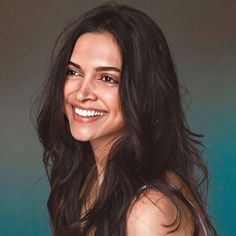 a woman with long dark hair smiling at the camera