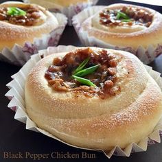 some food that is sitting on top of a black plate with white paper wrappers