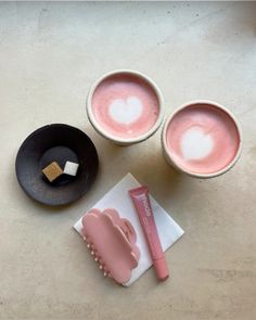 two mugs with marshmallows in them on a table next to other items