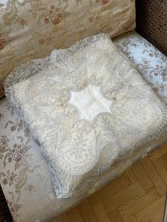 a white square pillow sitting on top of a wooden floor next to a couch cushion