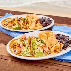 two white plates filled with tacos and black beans