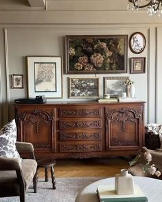 a living room filled with furniture and pictures on the wall