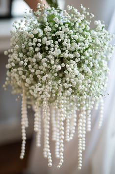 a bunch of white flowers hanging from a ceiling