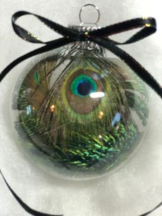 a glass ornament with a peacock's eye in it on a white surface