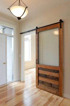 an empty room with a wooden door and glass sliding doors on the wall, along with hard wood flooring