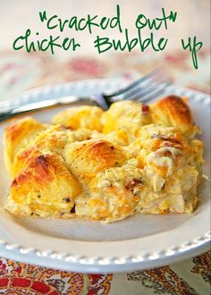 a white plate topped with cheesy chicken bubble up casserole next to a fork