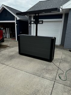 a large black box sitting on top of a cement floor in front of a garage