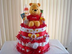 a winnie the pooh diaper cake on a table with red ruffles