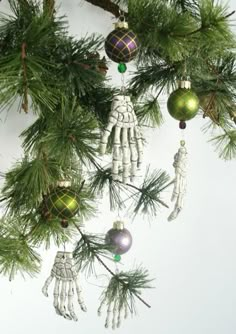 an ornament hanging from a christmas tree with skeleton hands and handprints