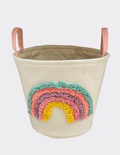 a white bucket with a rainbow design on the side and handles in pink, blue, yellow, green, orange