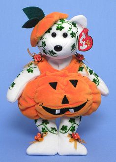 a teddy bear dressed up as a pumpkin wearing a hat and holding a jack - o'- lantern