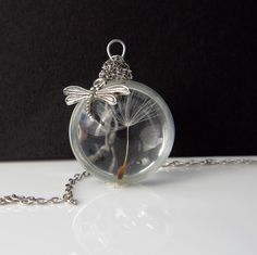 Unlock the beauty of nature with our exquisite Dandelion Necklace, featuring a real dandelion encapsulated in a stunning glass pendant that serves as a charming make-a-wish token. This unique piece of real dandelion jewelry not only showcases the enchanting intricacies of the dandelion, but it also evokes sentimental memories of childhood hopes and dreams. Perfect as a terrarium gift for her, this necklace adds a touch of whimsy to any outfit while inviting the wearer to embrace the magic of wis Dandelion Jewelry, Terrarium Gifts, Dandelion Necklace, The Dandelion, Terrarium Necklace, Dandelion Seed, Hopes And Dreams, Original Gift, Make A Wish