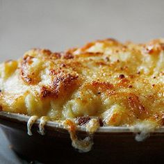 a casserole dish with cheese on top in a brown bowl, ready to be eaten