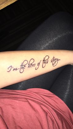 a person with a tattoo on their arm that says i'm the end of this story