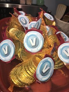 some gold coins are sitting on a red tray with the word v in white letters