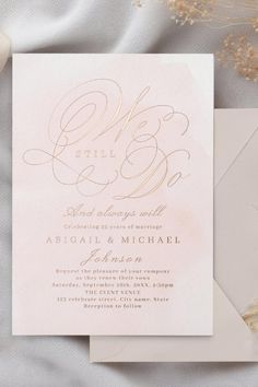 a wedding card with gold foil on the front and bottom, sitting next to a white envelope