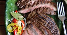 steak and vegetables on a green platter with a fork