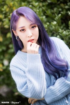 a woman with long purple hair posing for a photo