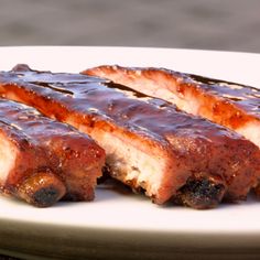 three pieces of barbecue ribs on a white plate