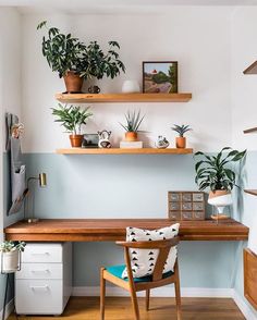 a desk with some plants on top of it and a chair in front of it