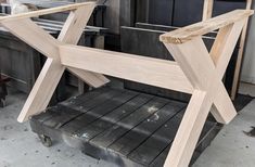 a chair made out of wood sitting on top of a piece of plywood in a shop