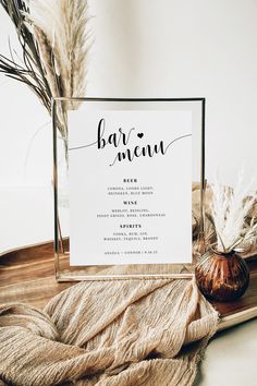 a table setting with a menu and some dried plants