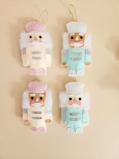 four small teddy bears are hanging on the wall, one is wearing a chef's hat