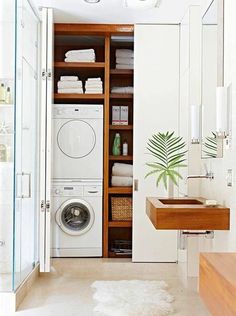 a washer and dryer in a bathroom with open shelving above the sink