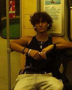 a man sitting on a subway train with his arms crossed