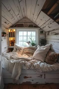 a window seat in the corner of a room with pillows and blankets on top of it