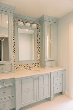 a bathroom with blue cabinets and marble counter tops