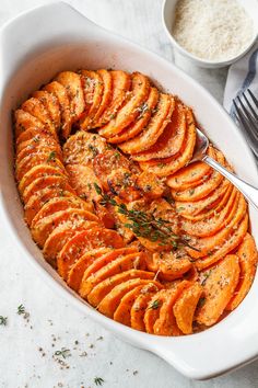 a white dish filled with sliced up sweet potatoes