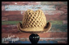 a brown crocheted hat sitting on top of a wooden table