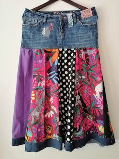 a colorful skirt hanging up on a hanger with polka dots and flowers in it