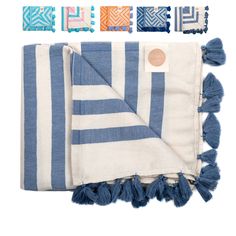 the blue and white striped blanket has tassels on it, along with several different colors