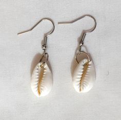 "These earrings are simple but beautiful, and perfect for any outfit and any occasion! They are made with a cowrie shell and a silver jump ring, earrings also come with rubber backings. Length: 1 3/4\" (from top of ear wire) Width: 1/2\" (shell) Due to it being handmade, earrings may differ slightly from pictures." Cheap Adjustable Shell Earrings, Nickel Free Adjustable Shell-shaped Earrings, Nickel-free Adjustable Shell-shaped Earrings, Casual Nickel-free White Earrings, Casual White Nickel-free Earrings, White Teardrop Earrings For Beach, Adjustable Silver Shell-shaped Earrings, White Earrings With Ear Wire For Vacation, White Ear Wire Earrings For Vacation