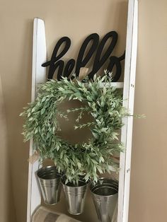 an old ladder is used as a shelf for potted plants and the word sale hangs on it