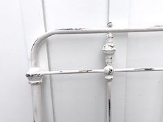 an old white metal bed frame with knobs