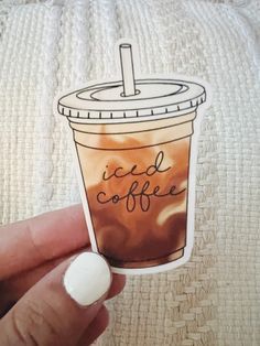 a hand holding a sticker with a cup of coffee on it