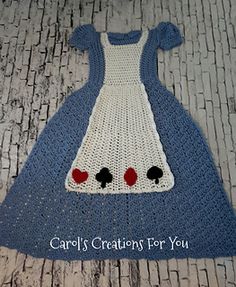 a crocheted blue dress with red hearts on the chest and black heart buttons