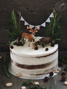 a cake decorated with deer and pine cones