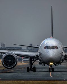 an airplane that is on the runway with lights on it's nose and landing gear down