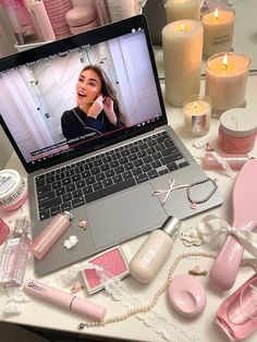 an open laptop computer sitting on top of a table next to candles and other items