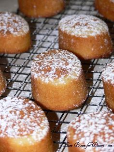 powdered sugar covered donuts cooling on a wire rack