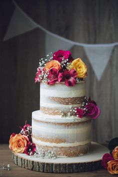 a three tiered cake with flowers on top