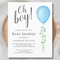 a baby shower is shown with a blue balloon and greenery on the bottom of it