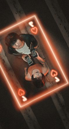 two people standing next to each other in front of a neon light frame on the floor