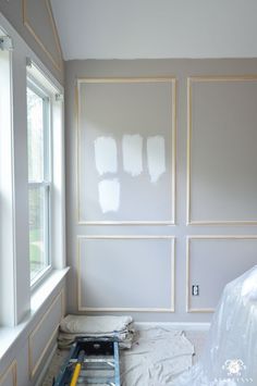 a room that has been painted white and is being worked on with paint rollers